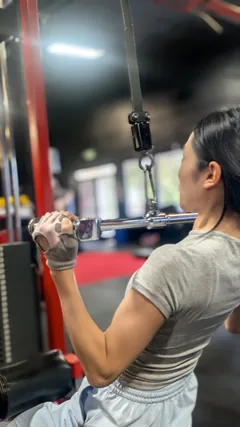 A woman using a cable pulldown machine.